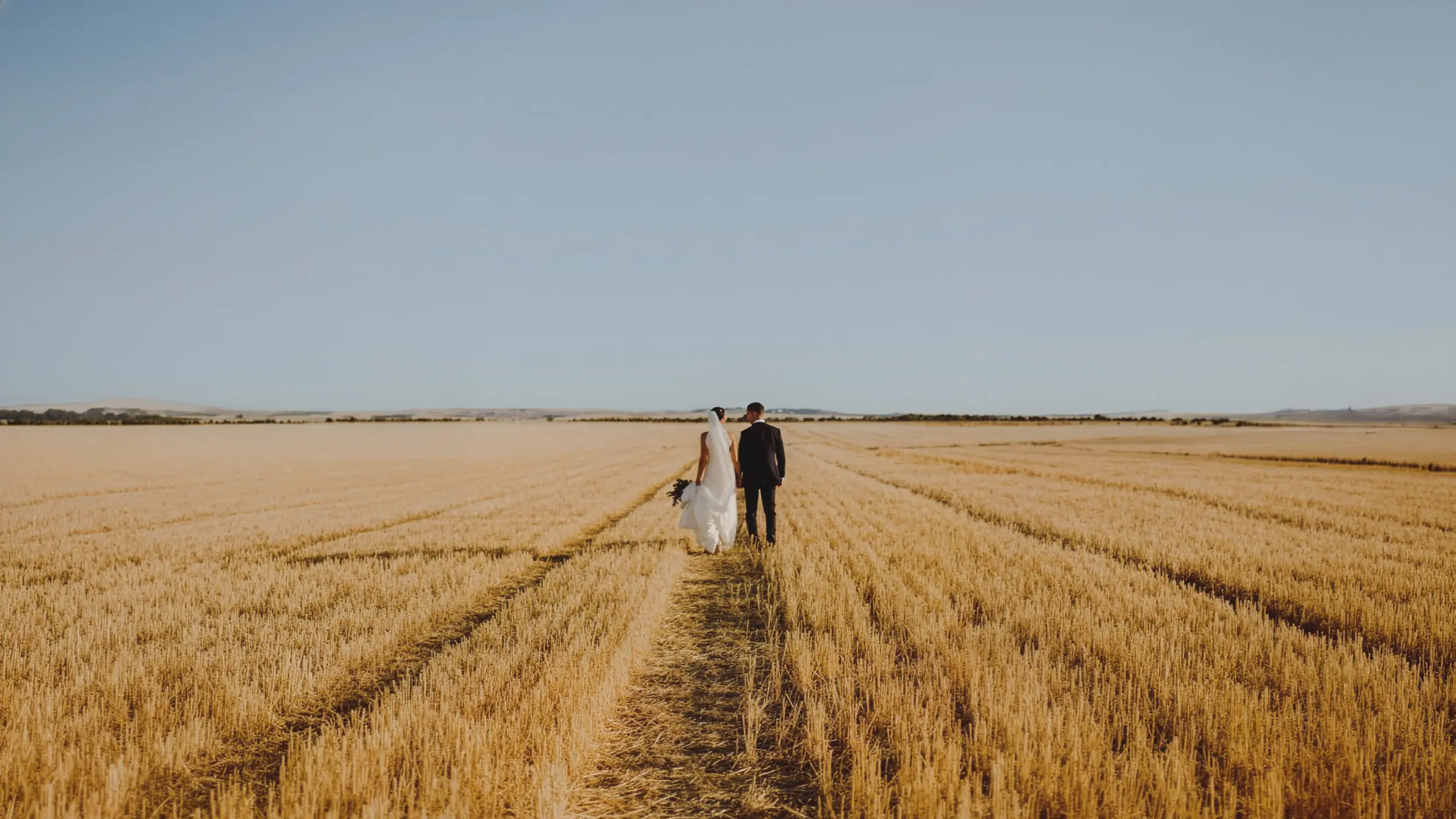 Pareja caminando entre campos de trigo